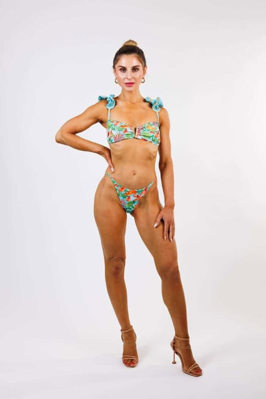 Model wearing the Bella Cheeky Bikini Bottom by Zinzina Swimwear, styled for luxury coastal escapes