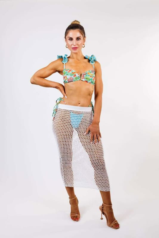 The model is wearing the Luna Crochet Skirt by Zinzina Swimwear, which is styled for luxury coastal escapes.