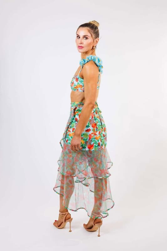The model is wearing the Sofia Wrap Skirt by Zinzina Swimwear, which is styled for luxury coastal escapes.