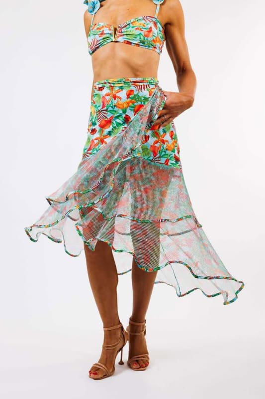 The model is wearing the Sofia Wrap Skirt by Zinzina Swimwear, which is styled for luxury coastal escapes.