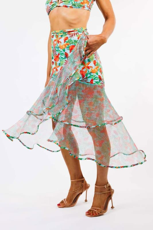 The model is wearing the Sofia Wrap Skirt by Zinzina Swimwear, which is styled for luxury coastal escapes.